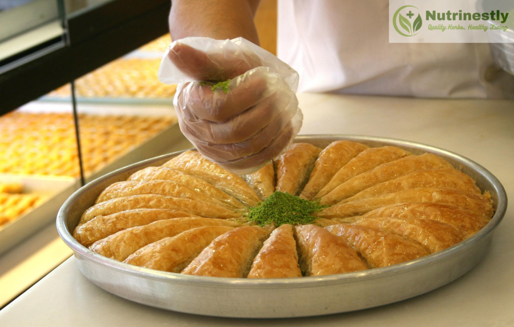 A platter of Baklava dessert coated with pistachio powder