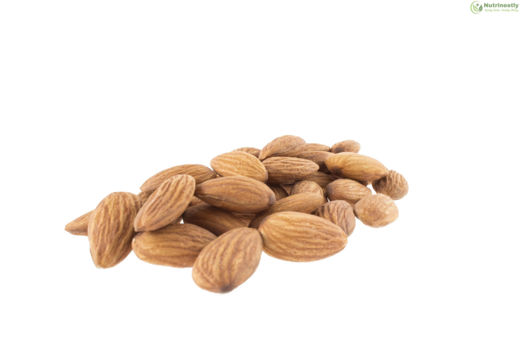 Close-up of raw almonds scattered on a white background, a healthy snack rich in nutrients.